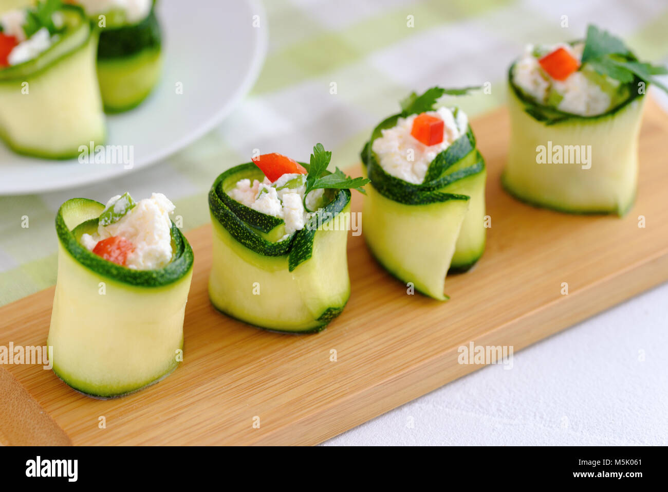 Rouleaux de courgettes farcies au fromage et ciboulette et paprika rouge. Banque D'Images