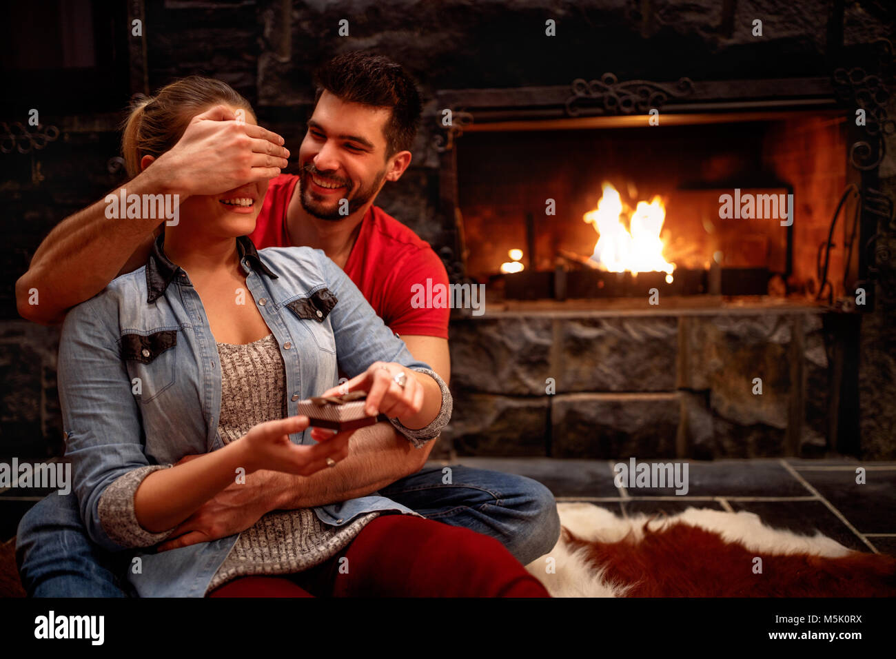 Petit ami tient sa petite amie alors qu'elle les yeux couverts, donner un cadeau surprise romantique Banque D'Images