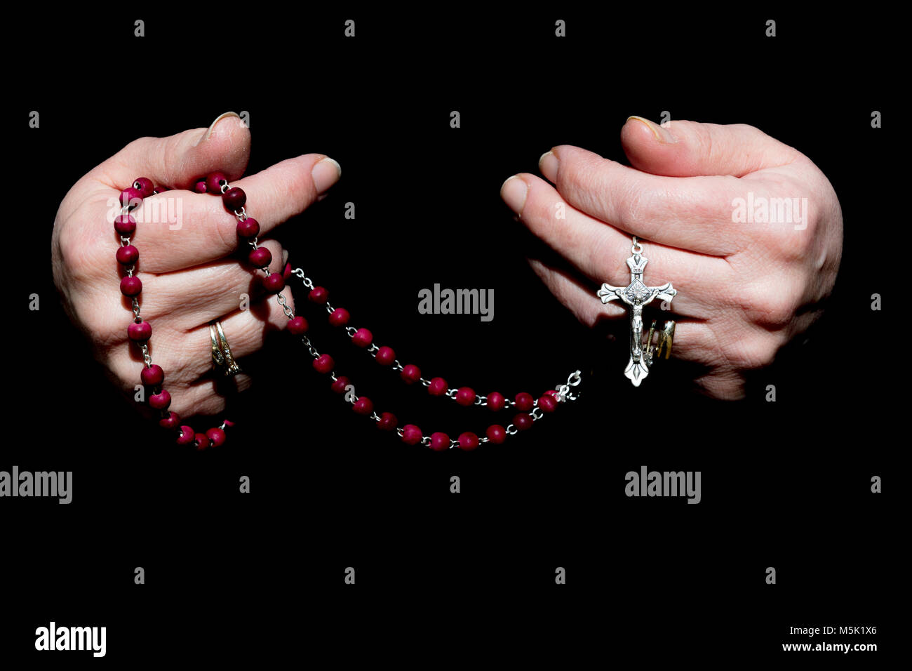Female Hands Holding Rosary. Isolated on Black Banque D'Images