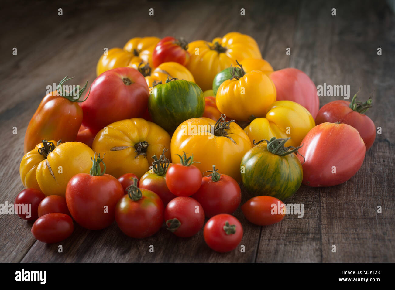 Tomates colorées sur fond de bois rustique. Banque D'Images