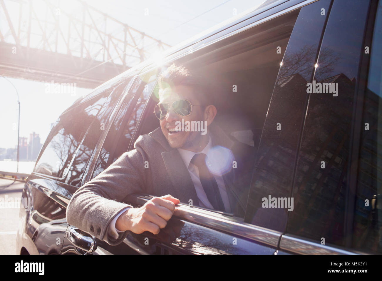 Jeune homme d'affaires à regarder par la fenêtre sitting in car limousine service Banque D'Images