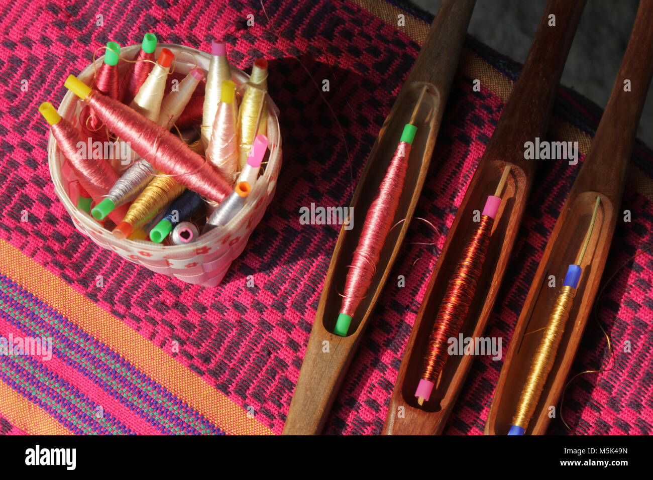 Bobines colorées dans le panier et de canette sur tissu de soie, le tissage traditionnel de la soie thaïlandaise Banque D'Images