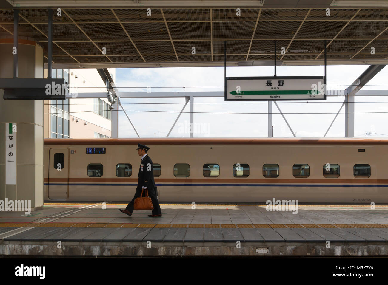 Former le personnel à la marche des travailleurs la gare devant un train, dans la plate-forme de Nagano, Japon Banque D'Images