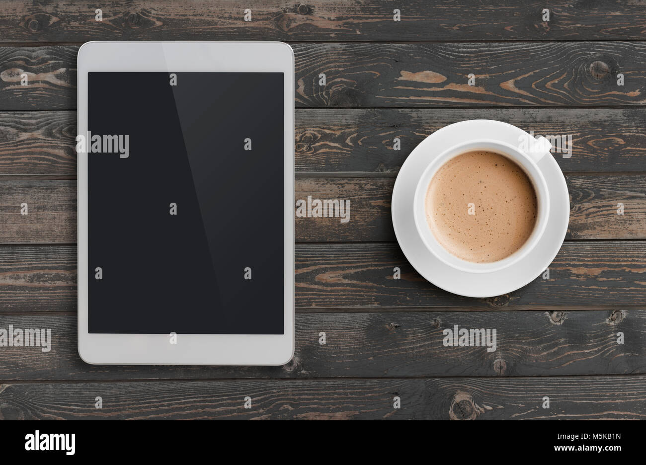 Tasse à café et tablet pc sur table en bois sombre vue de dessus Banque D'Images