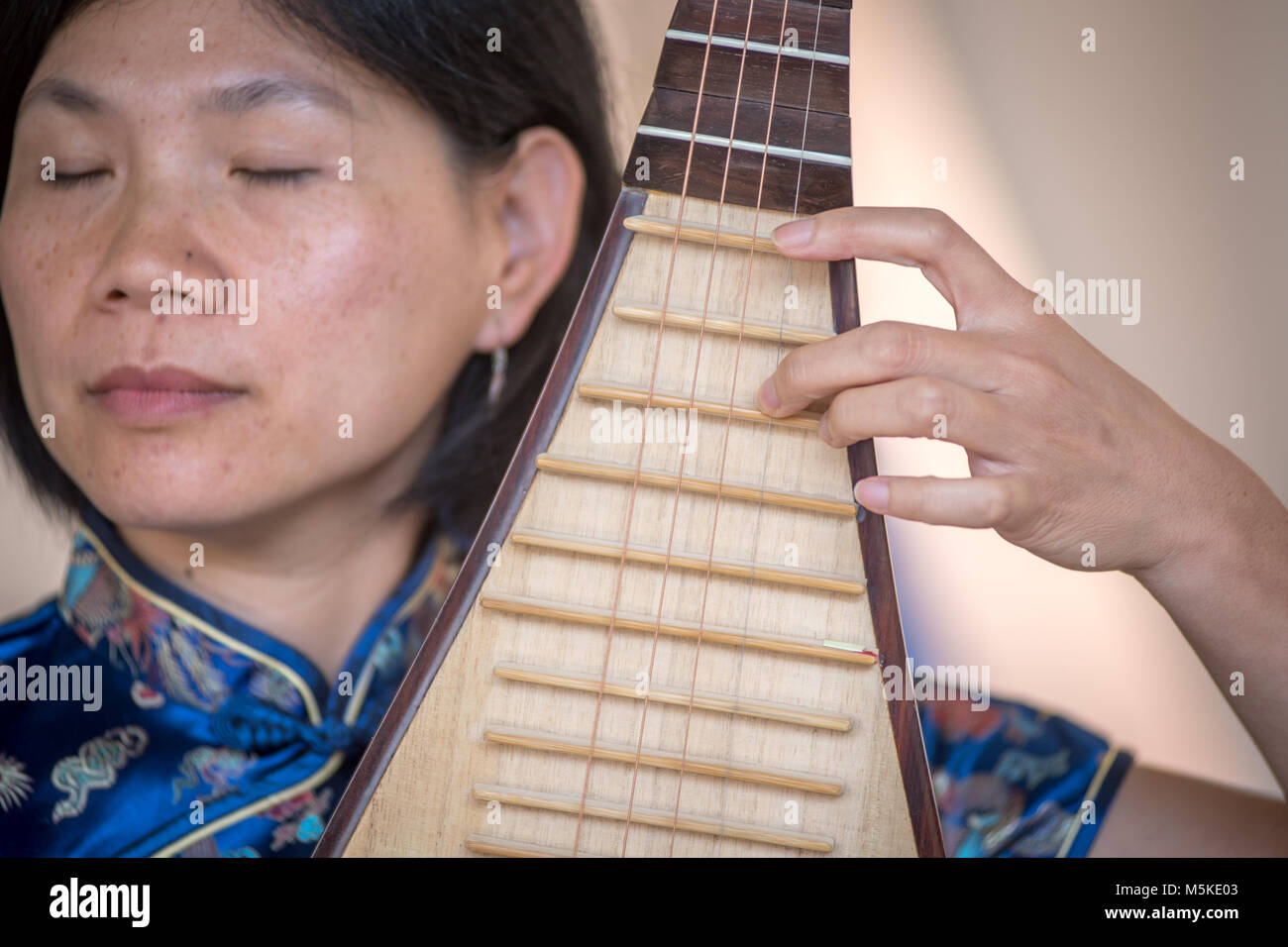 Chen de Yihan, partie d'Ann Yao Trio, démontre l'accent incroyable comme elle joue du pipa chinois traditionnels, Greensboro, Caroline du Nord. Banque D'Images