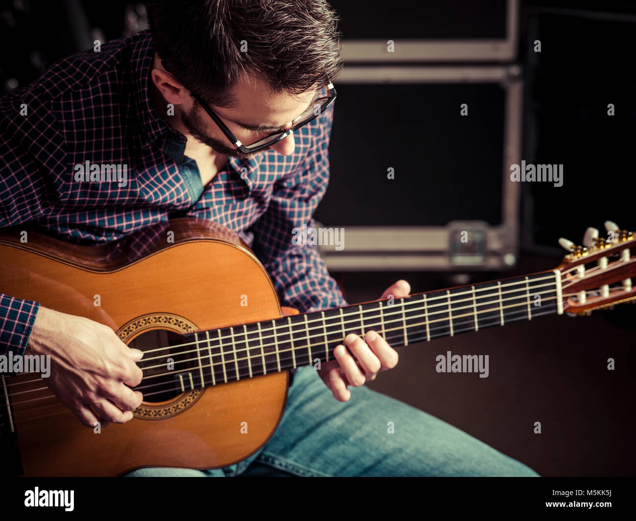 Photo d'un homme jouant de la guitare acoustique dans un studio de répétition. Se concentrer sur la tête de l'homme. Banque D'Images