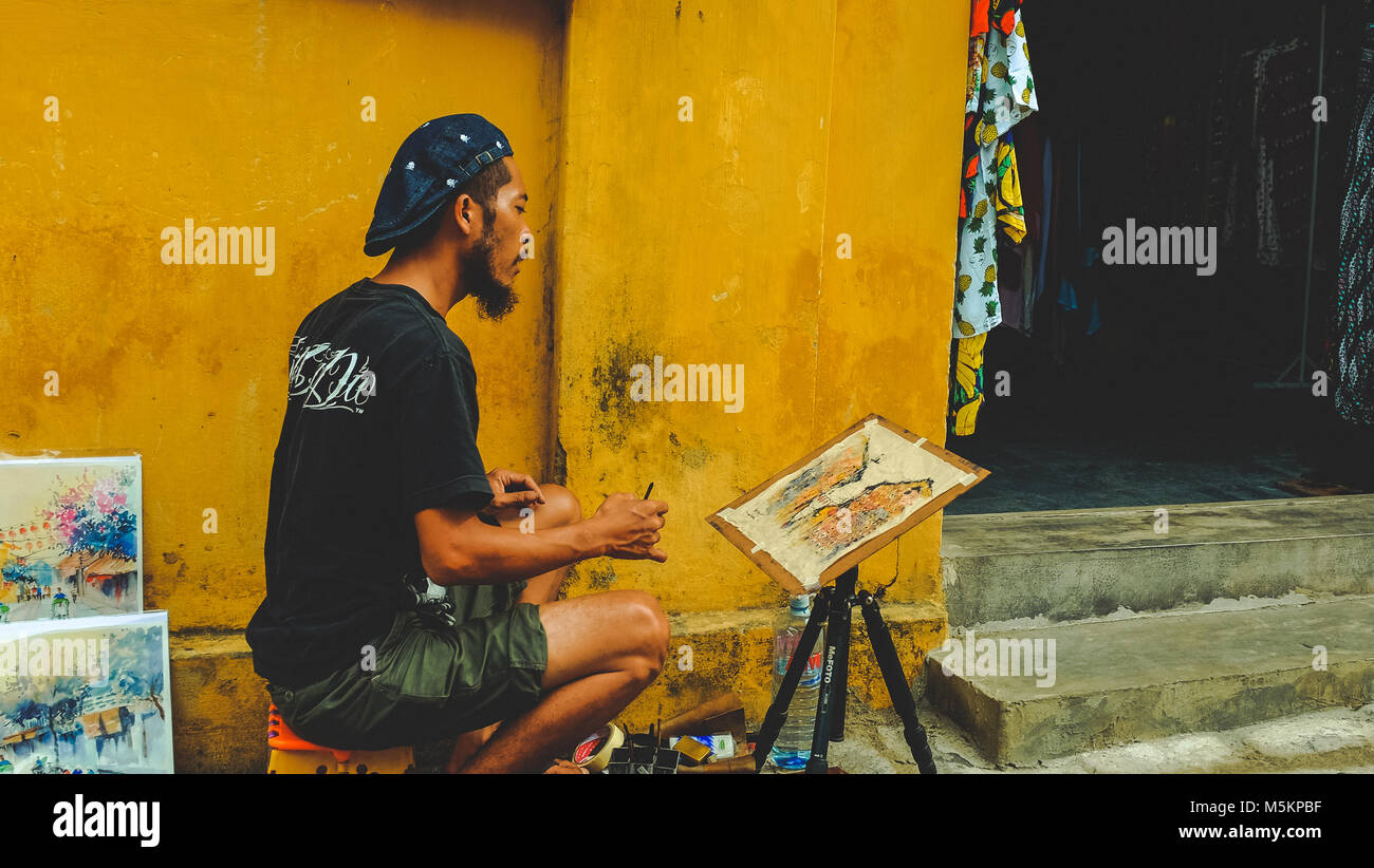 Peinture d'un homme sur le côté de la rue à Hoi An, Vietnam Banque D'Images