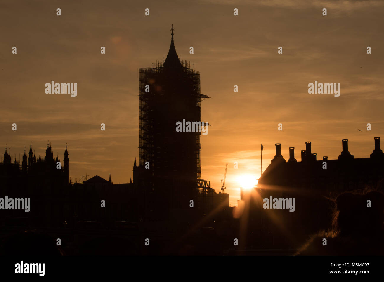 Londres, Royaume-Uni. 24 Février, 2018. Big Ben ou l'Elizabeth Tower, London, UK. 24 février 2018. Le soleil se couche à côté de Big Ben qui est couverte d'échafaudages.. Credit : Carol Moir/Alamy Live News. Banque D'Images