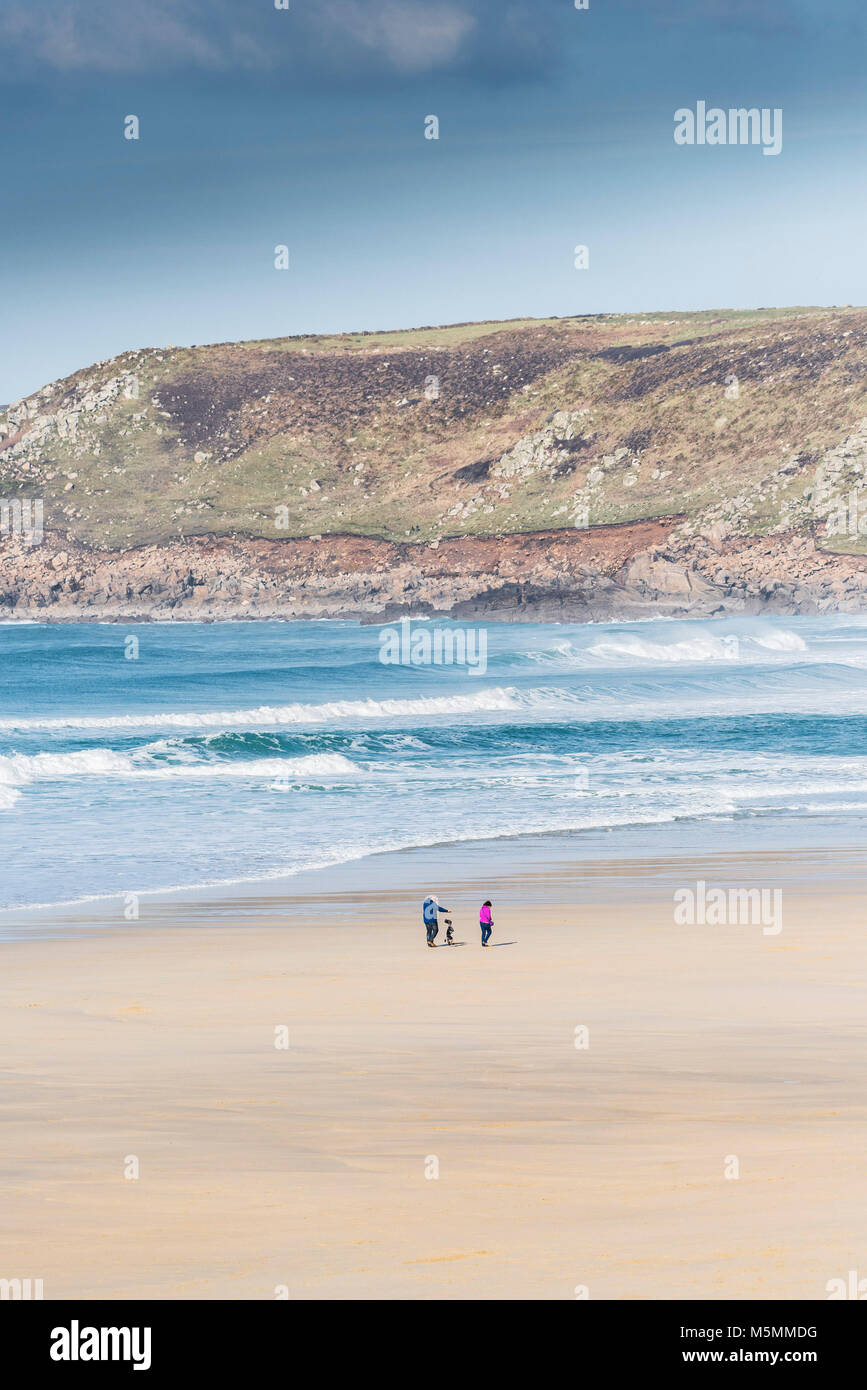 Les promeneurs de chiens sur la plage de Sennen Cove à Cornwall. Banque D'Images