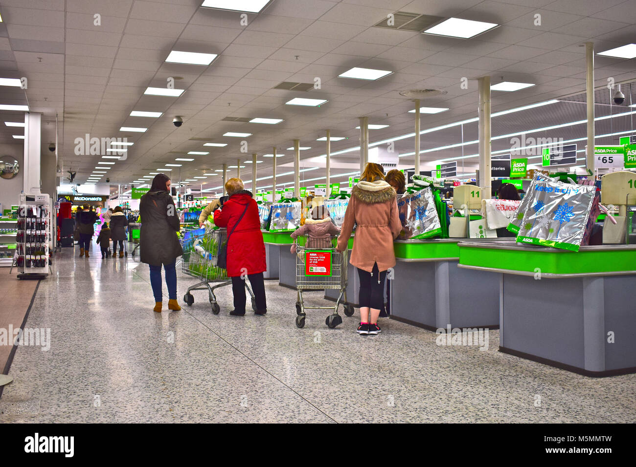 Des caisses en laissant les acheteurs au supermarché Asda moderne à Dyffryn, Newport, Pays de Galles SE. Banque D'Images