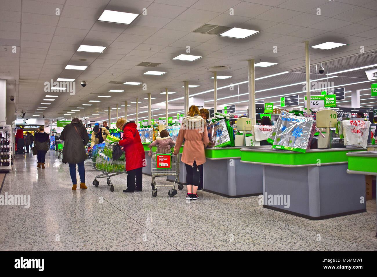 Des caisses en laissant les acheteurs au supermarché Asda moderne à Dyffryn, Newport, Pays de Galles SE. Banque D'Images