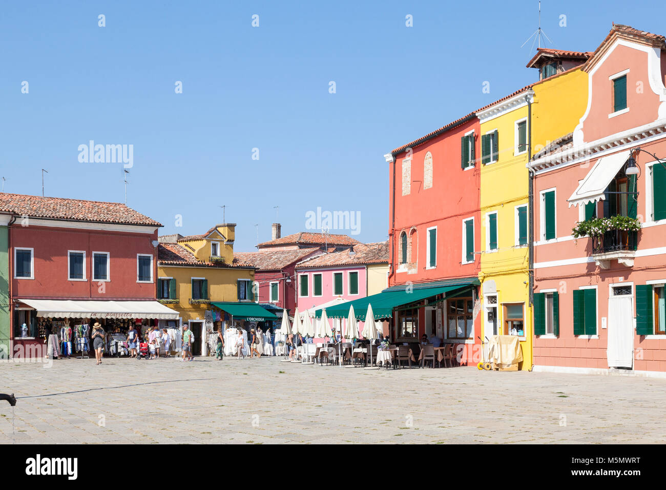 Les touristes du shopping dans des boutiques colorées sur la Piazza Baldassare Galuppi, Burano, Venise, Vénétie, Italie Banque D'Images