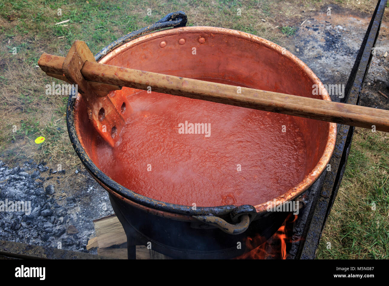 La cuisson des fruits vers le bas pour rendre le beurre de pomme dans une grande bouilloire sur le feu. Banque D'Images