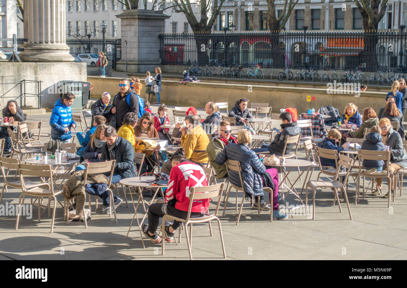 Les gens au café tables à l'extérieur Le British Museum (dédié à l'histoire humaine, l'art et la culture), sous le soleil d'hiver février Journée à Londres, Angleterre, Royaume-Uni. Banque D'Images