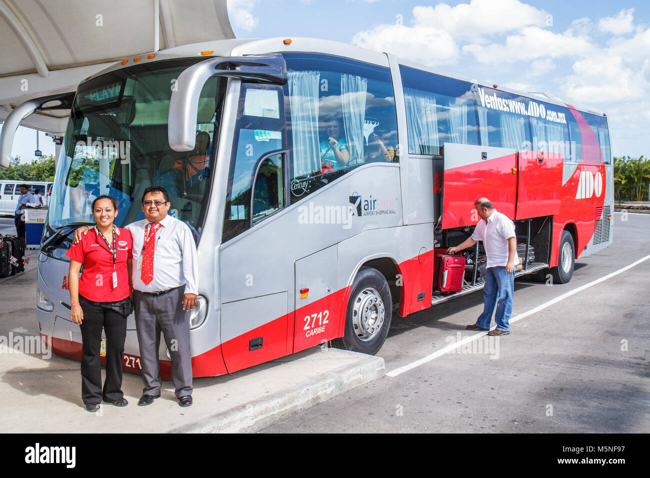 Cancun Mexique, Mexicain, Cancun International Airport, femme hispanique femmes, bus ADO, autocar, transport terrestre, agent de billets, chauffeur, bagages, suitcas Banque D'Images