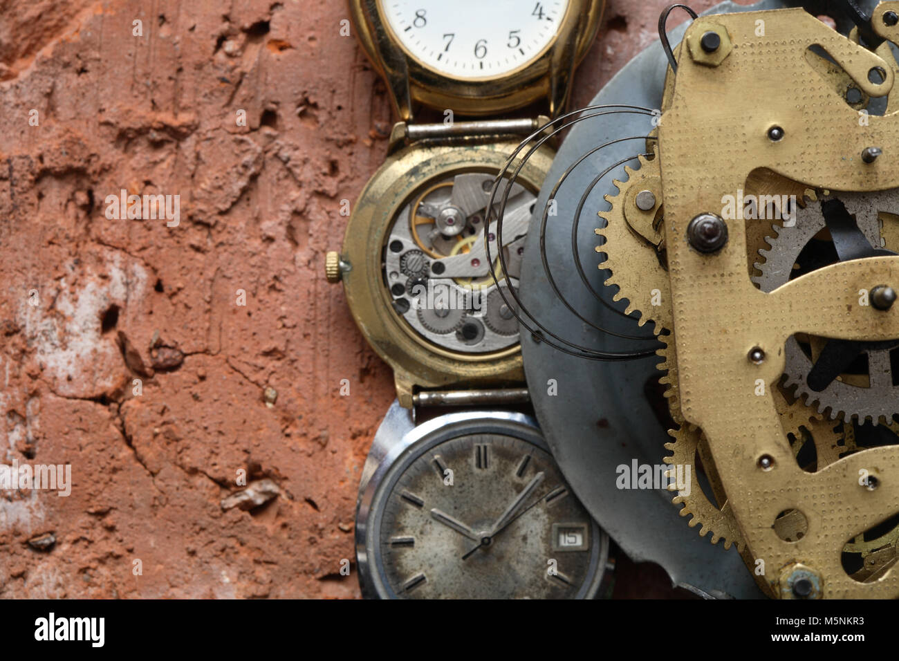 Libre de l'ancien mécanisme de l'horloge en laiton et des montres sur fond de brique rouge avec copie espace Banque D'Images