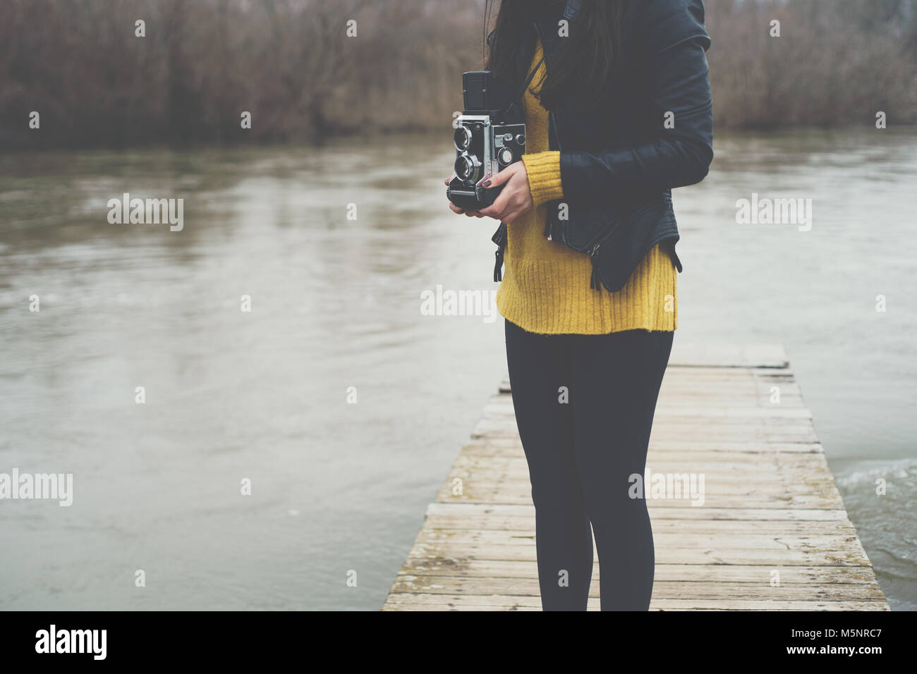 Jeune femme prenant des photos avec l'appareil photo retro vintage Banque D'Images