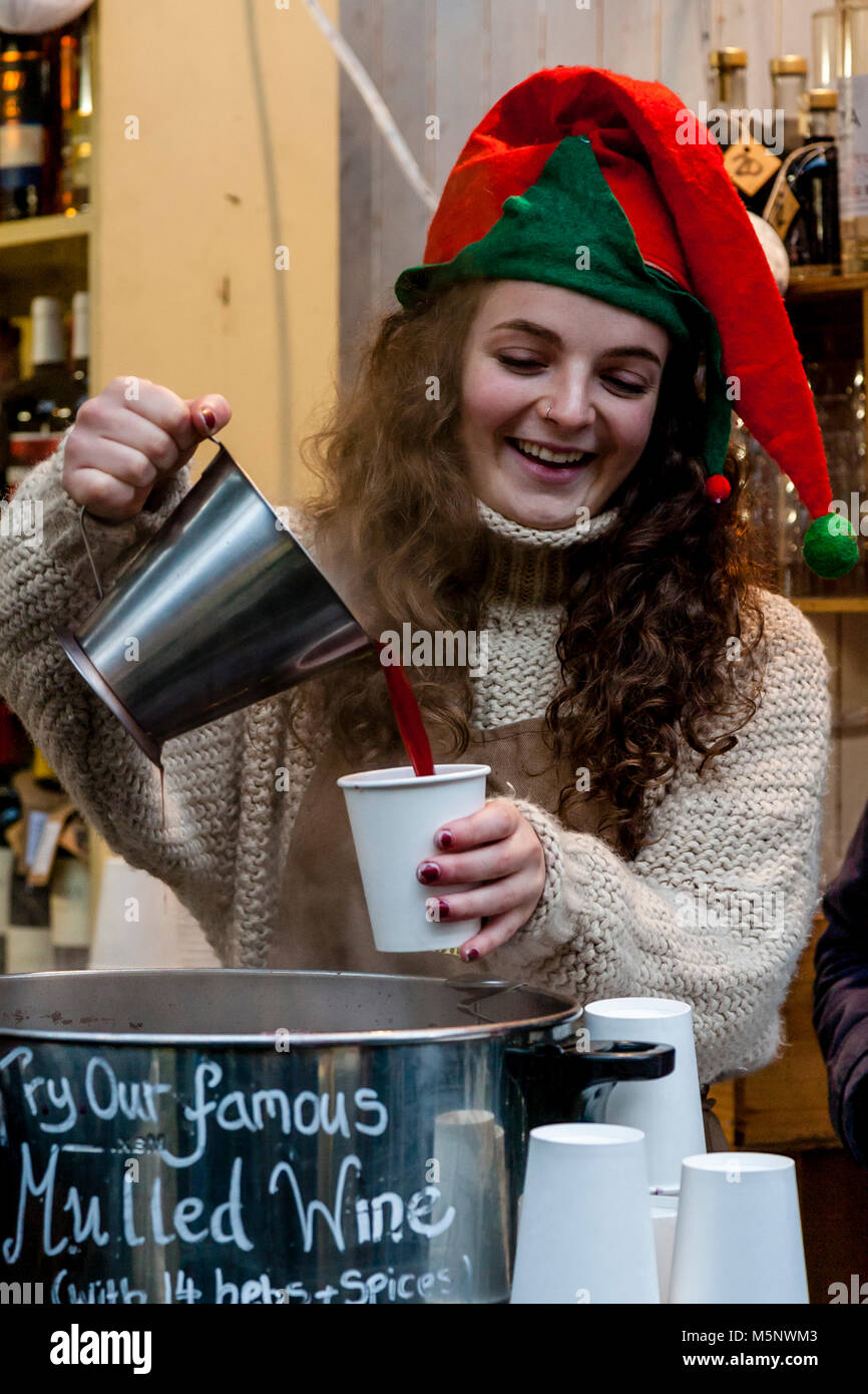 Une jeune femme vendant du vin chaud à Borough Market à l'époque de Noël, Londres, UK Banque D'Images