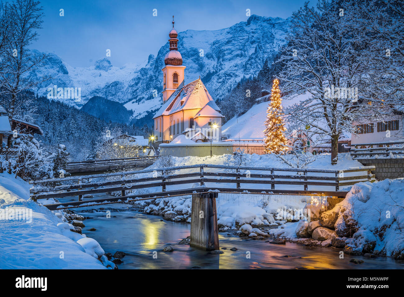 Crépuscule sur Sankt Sebastian église de pèlerinage avec arbre de Noël allumé pendant l'heure bleue à la tombée de la nuit en hiver, Ramsau, Bavière, Allemagne Banque D'Images