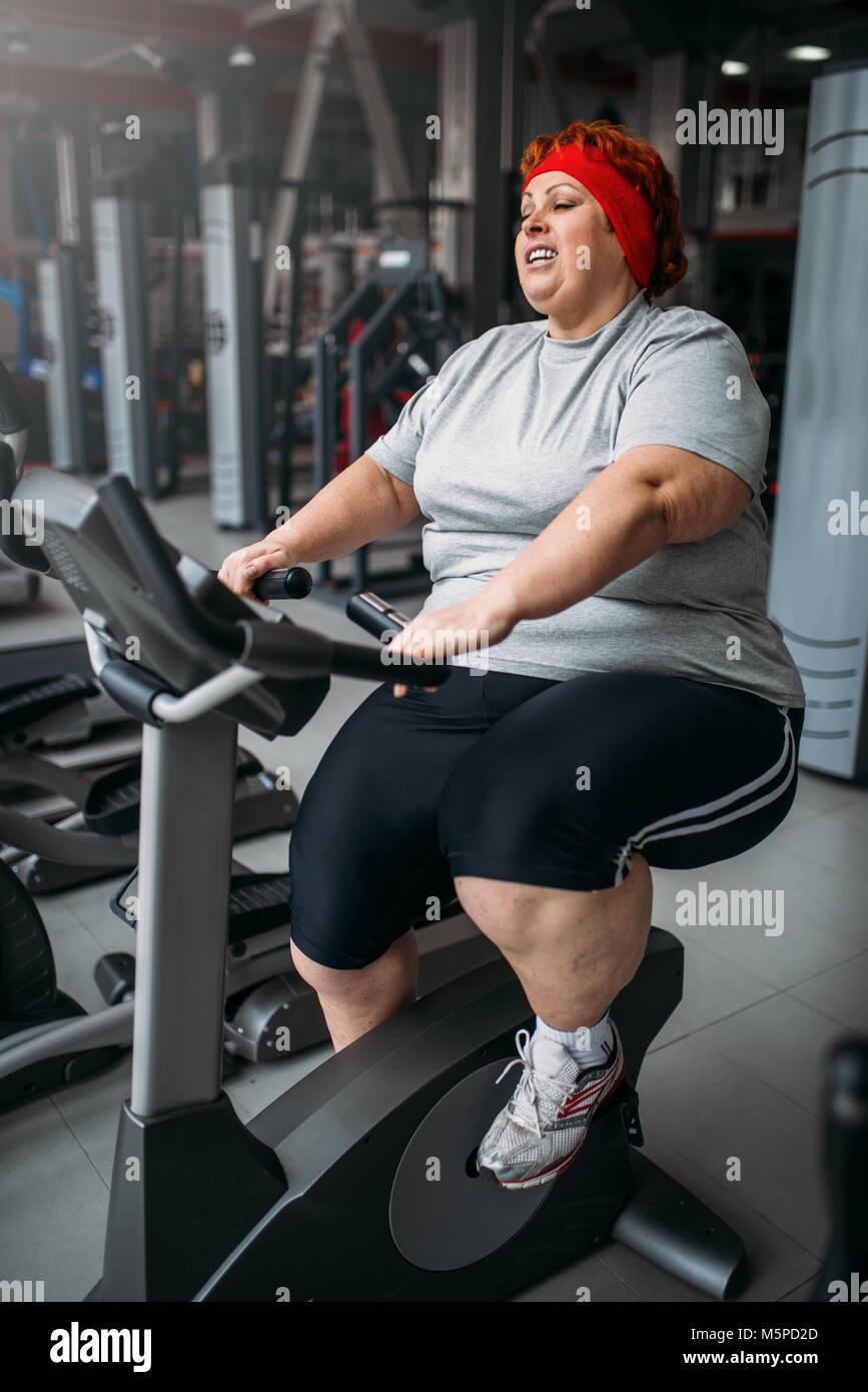 Grosse femme formation sur un vélo d'exercice dans la salle de sport.  Calories de brûlure, de femmes obèses personne dans le sport club Photo  Stock - Alamy
