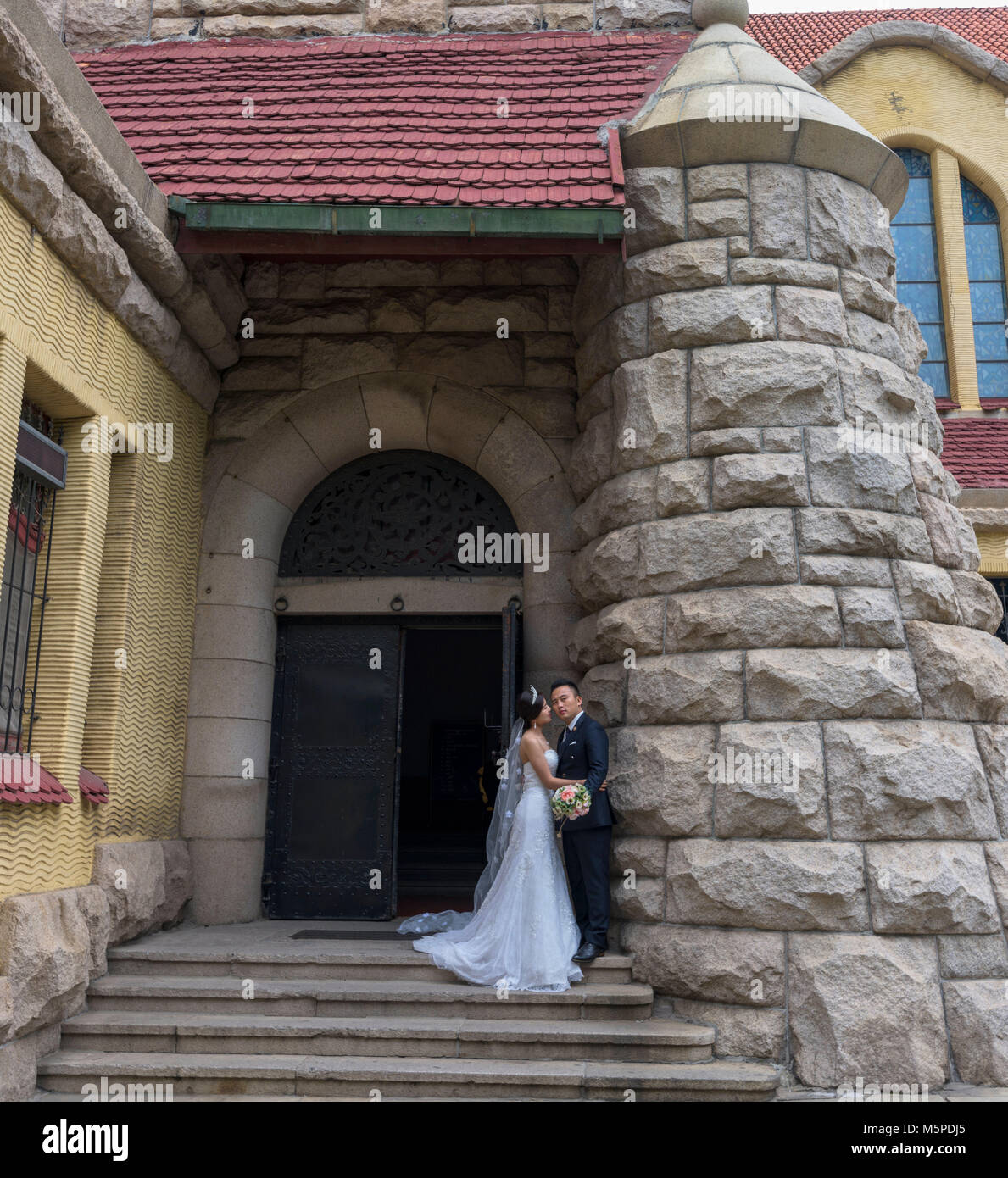 Des couples affluent à Qingdao église protestante d'avoir leurs photos de mariage. Il est l'un des célèbres églises construites par les Allemands. Banque D'Images