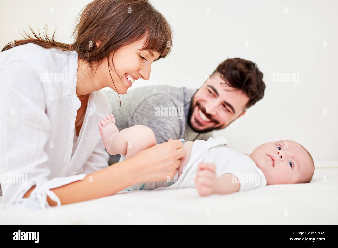 Mère et père en même temps modifier les couches pour son petit bébé Banque D'Images