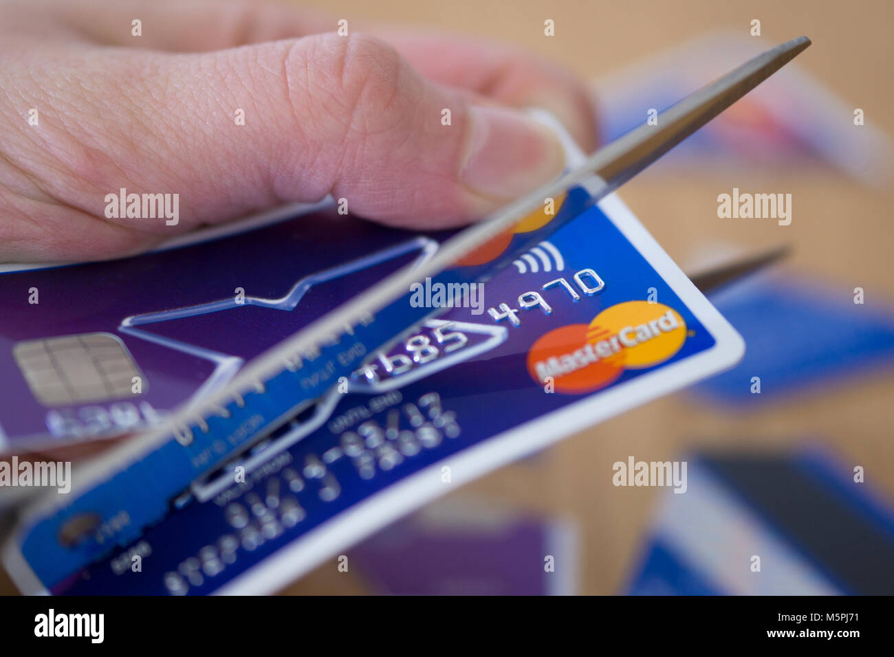 Un gros plan d'une femme de couper une carte de crédit - concept de la dette de carte de crédit Banque D'Images
