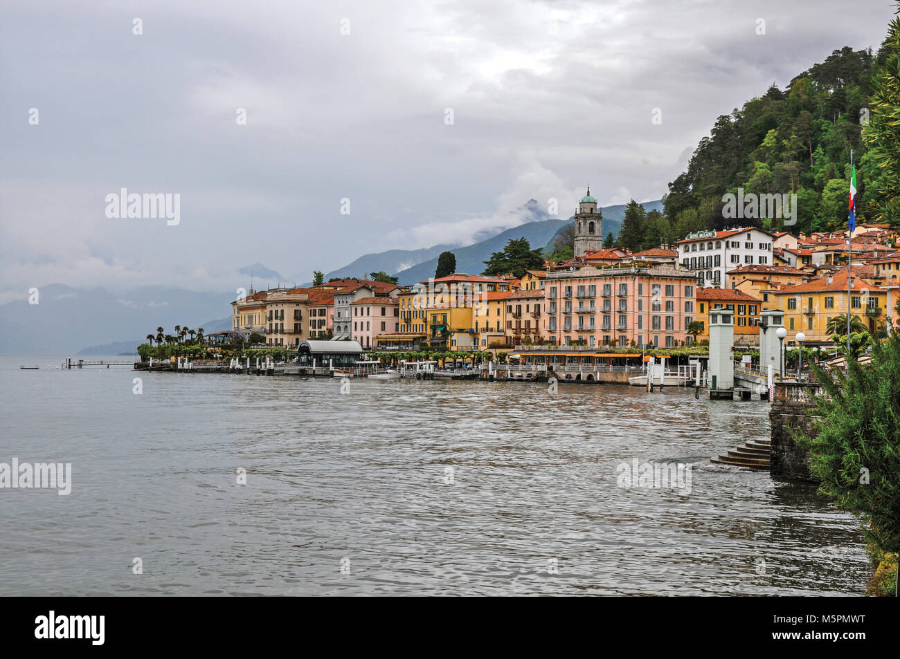 Vue sur le lac de Côme en journée nuageuse avec les bâtiments de Bellagio, un charmant village touristique entre le lac et les montagnes des Alpes. Banque D'Images