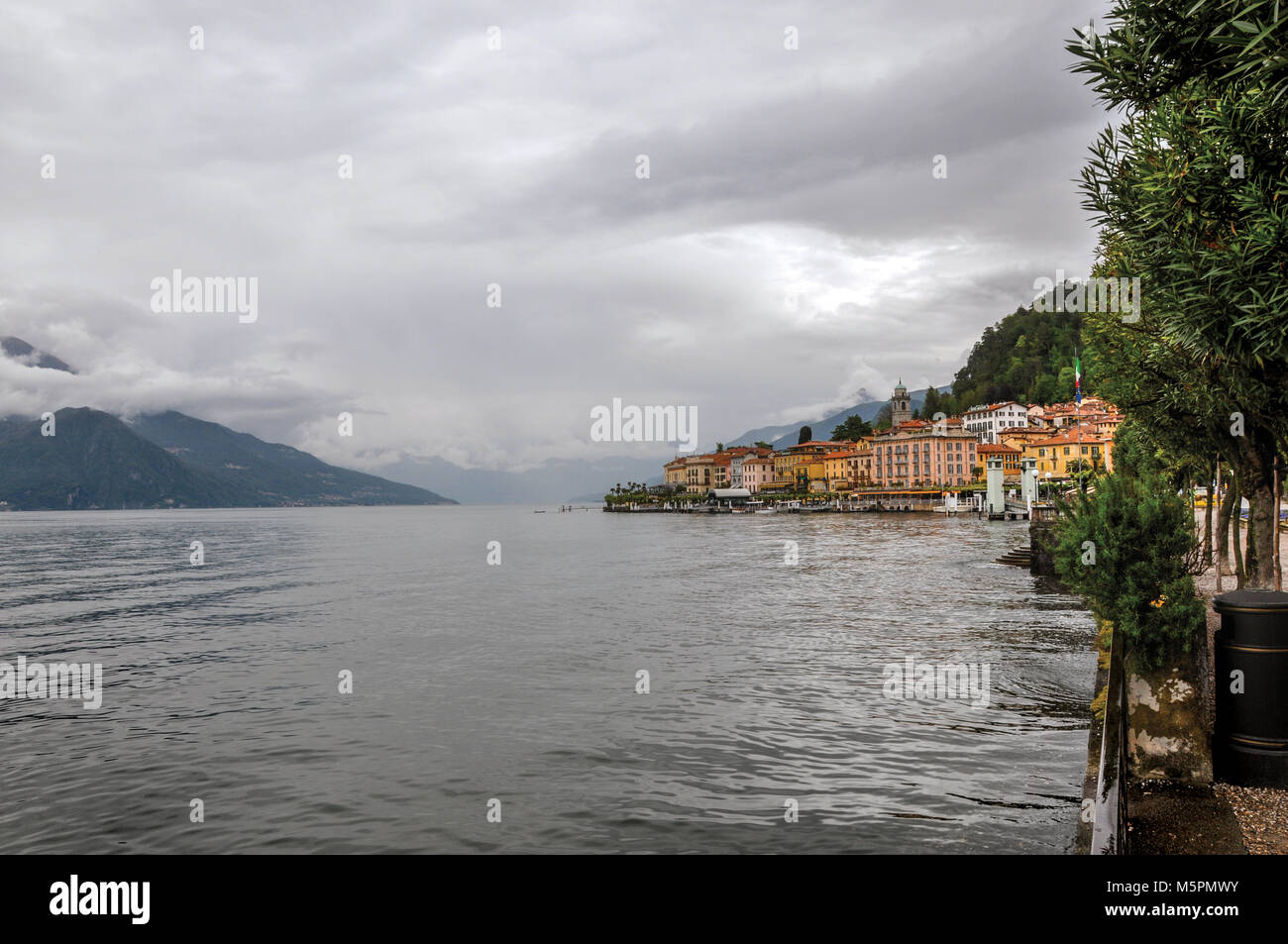 Vue sur le lac de Côme en journée nuageuse avec les bâtiments de Bellagio, un charmant village touristique entre le lac et les montagnes des Alpes. Banque D'Images