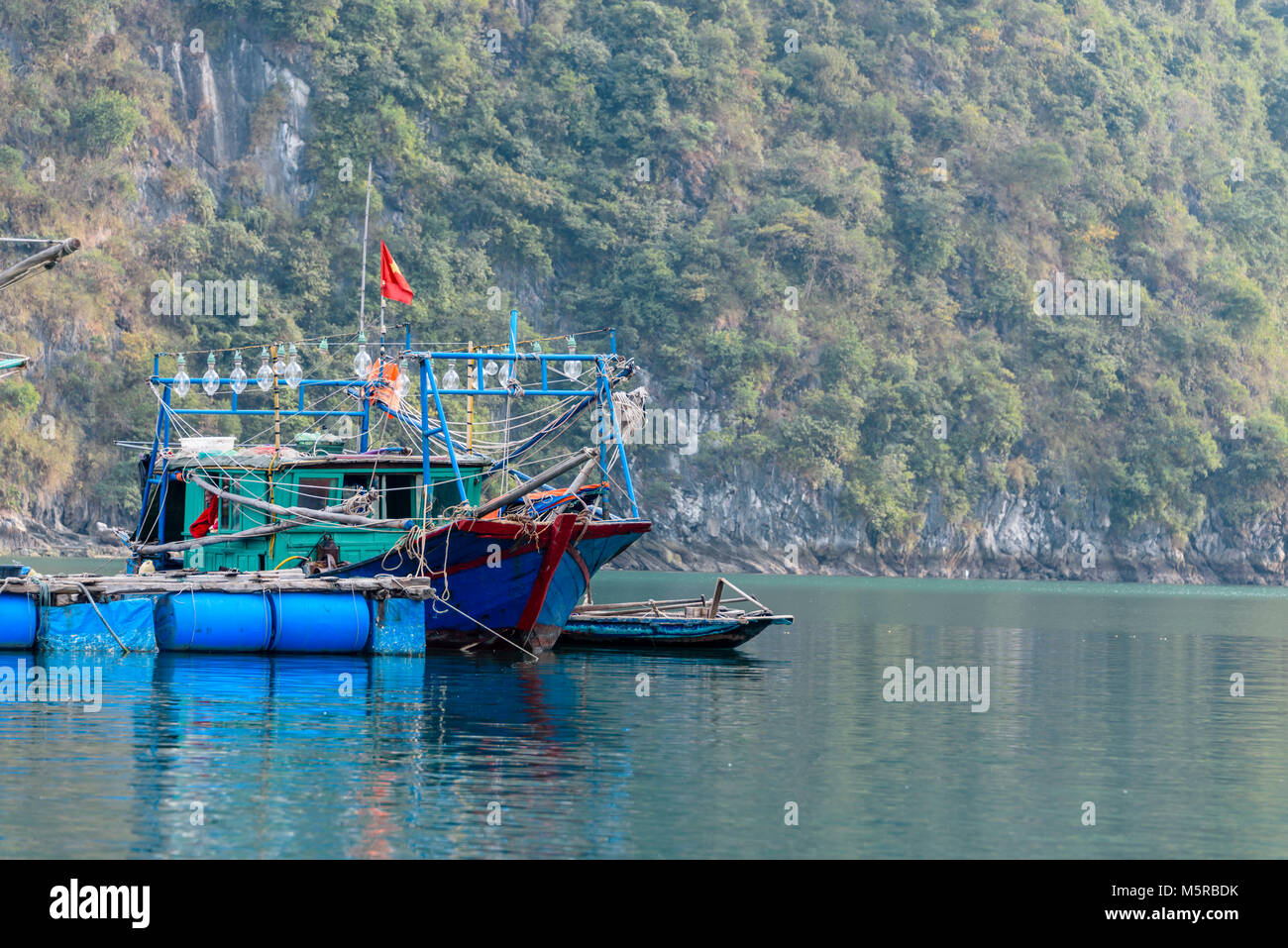 Calmar traditionnel bateau de pêche avec un éclairage à l'AUC Van village flottant, Halong Bay, Vietnam Banque D'Images