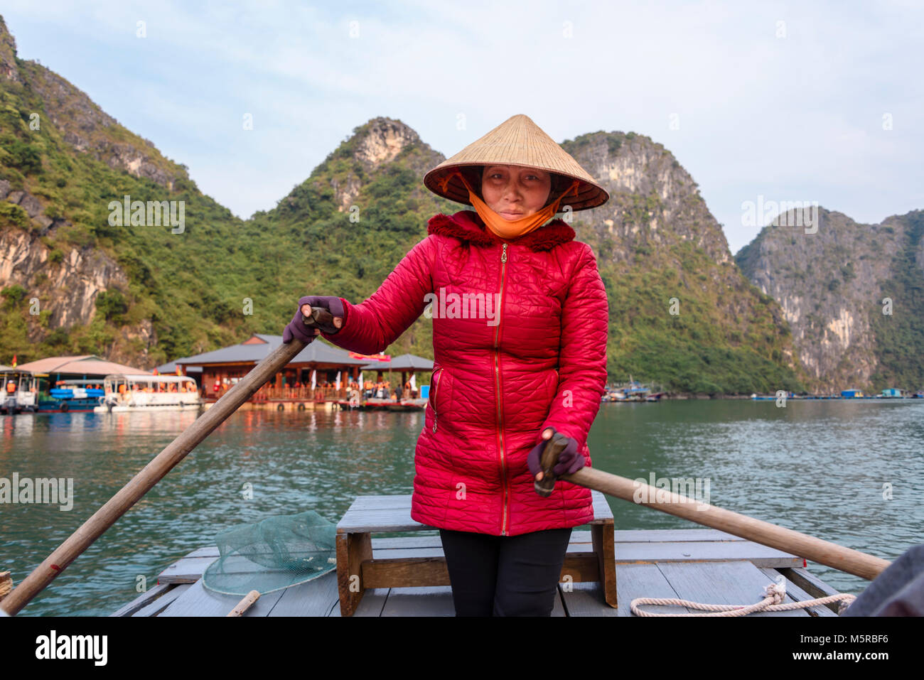 Vietnamese woman wearing traditional bamboo chapeau conique dans un bateau  à rames au transport des passagers autour de l'AUC Van village flottant,  Halong Bay, Vietnam Photo Stock - Alamy