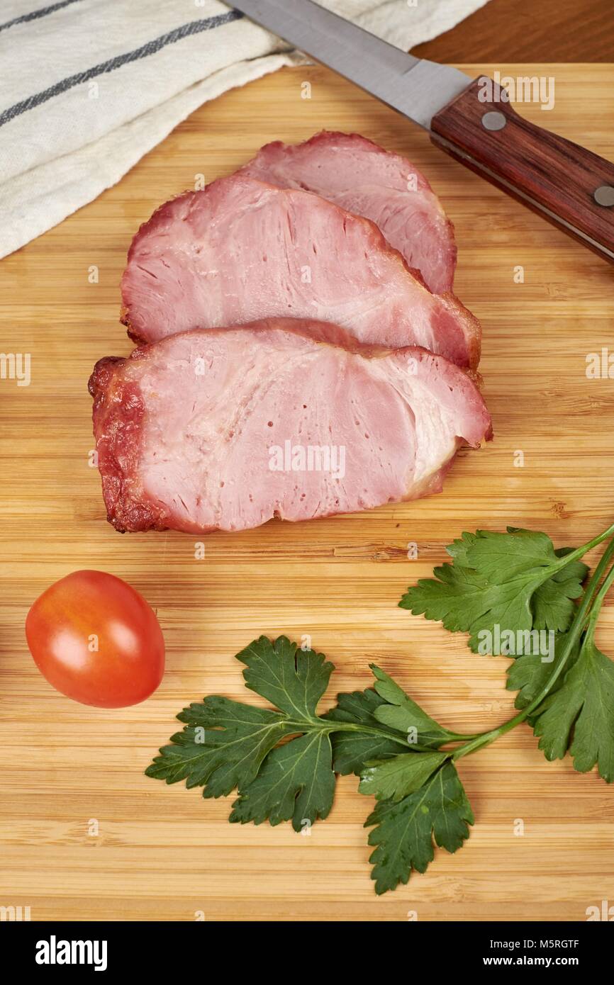 Steak de jambon de porc cuit sur planche à découper en bois. Banque D'Images