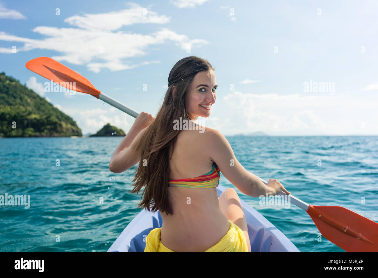 Young woman paddling un canot sur la mer pendant les vacances d'été Banque D'Images