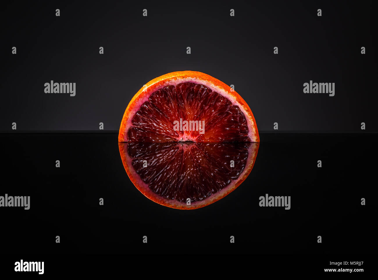 La moitié de l'orange sanguine sur chemin de détourage fond noir Banque D'Images