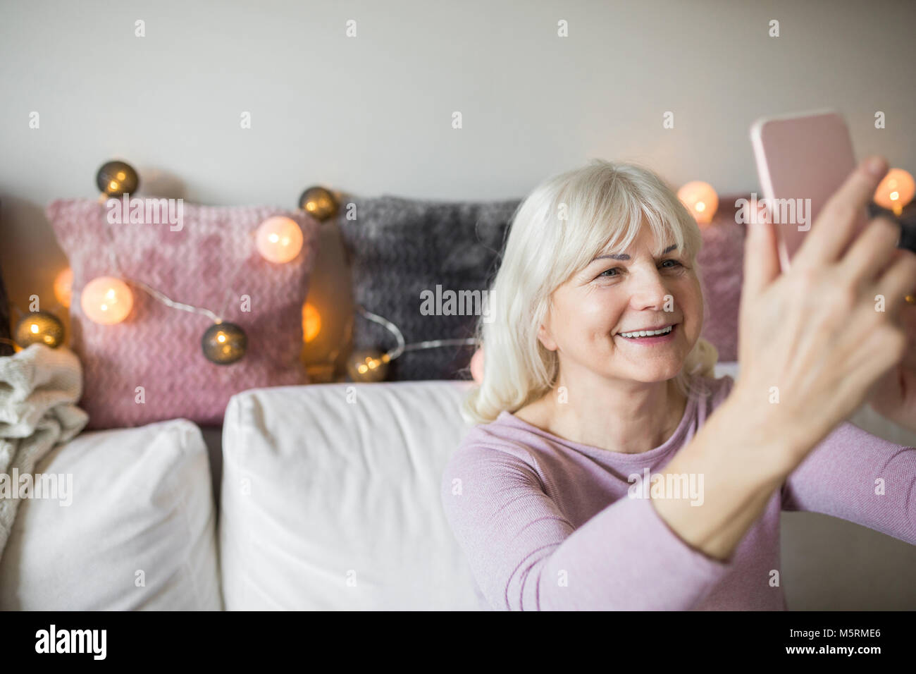 Portrait of happy senior lady en tenant par mobile selfies Banque D'Images