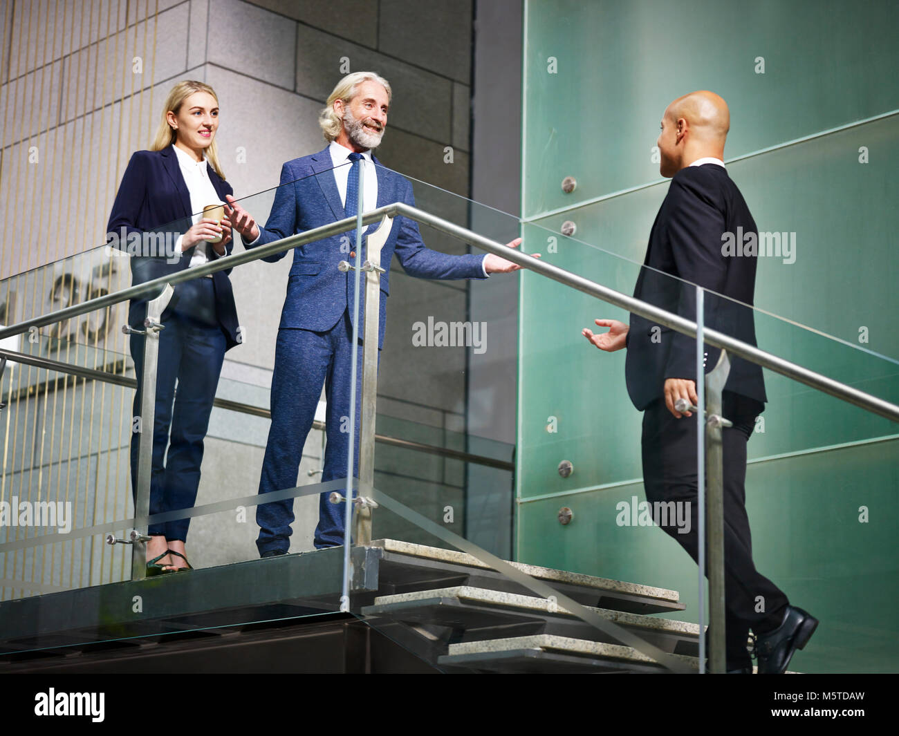 Directeur général accueillant des visiteurs sur des simulateurs d'immeuble de bureaux modernes, low angle view. Banque D'Images