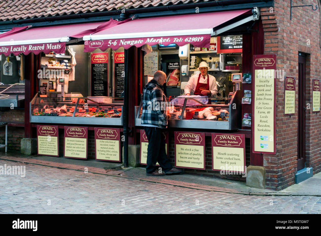 Un homme d'acheter la viande de boucherie Swains caler au marché de New York Banque D'Images