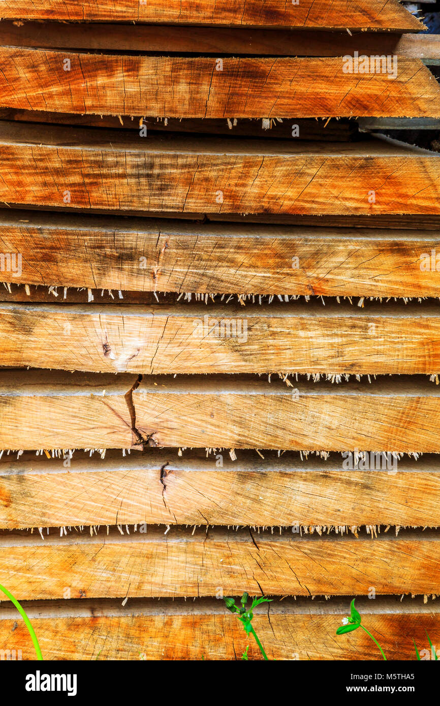 Des piles de bois d'assaisonnement dans le soleil prêt à l'utilisation dans des bâtiments historiques et des projets. Banque D'Images