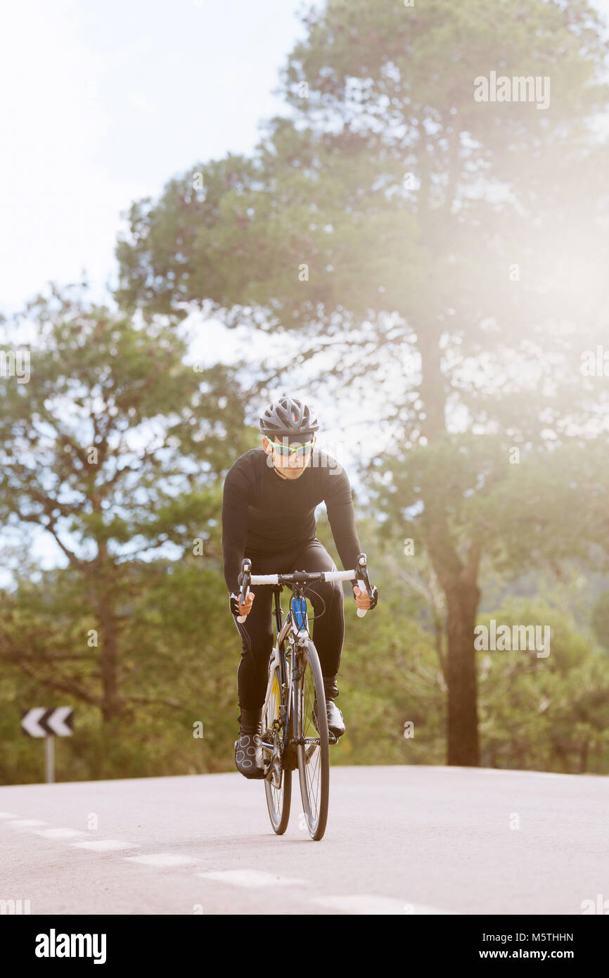 Vue d'un cycliste en descendant mâle d'une route de campagne. Vélo de triathlon sur une bicyclette Banque D'Images