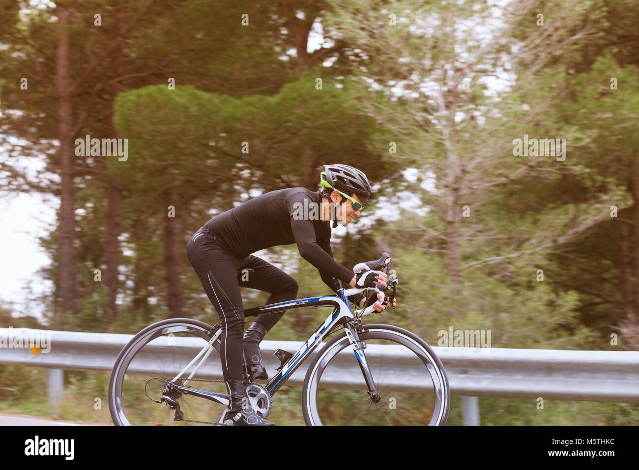 Vue d'un cycliste en descendant mâle d'une route de campagne. Vélo de triathlon sur une bicyclette Banque D'Images