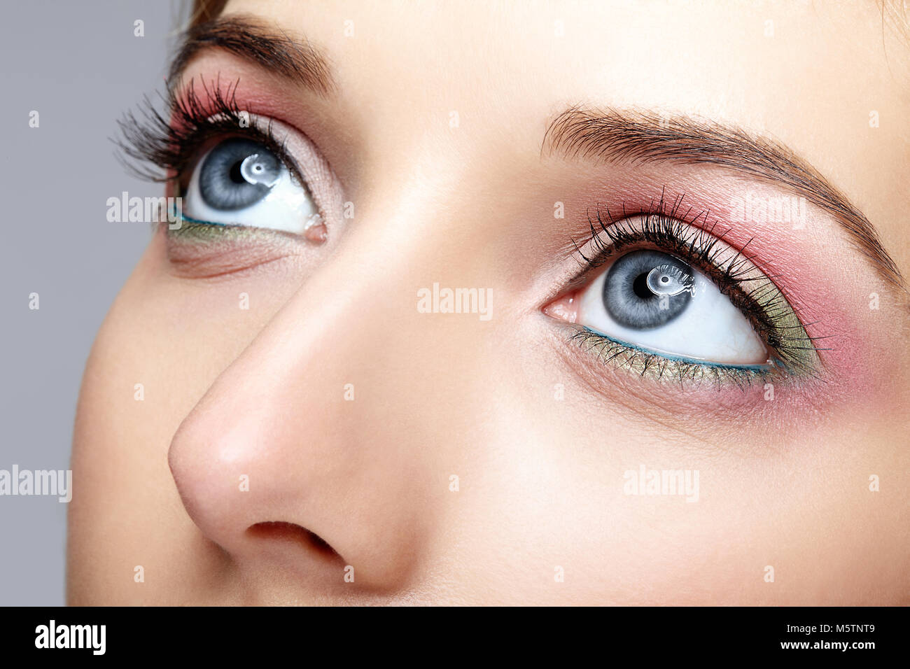 Closeup macro shot de la femme avec des yeux bleu vert rose et un miroir Banque D'Images