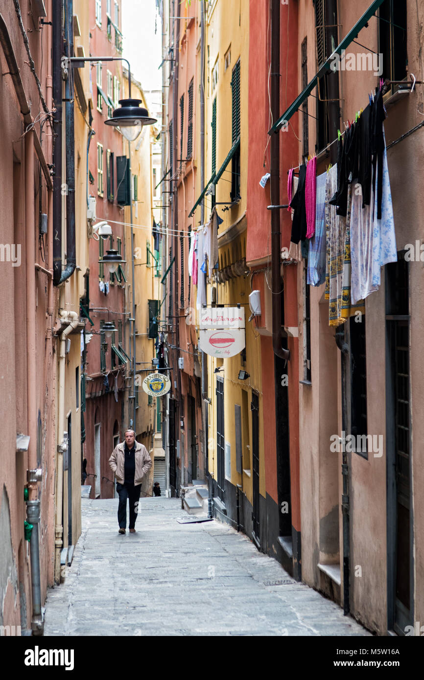 Homme marchant dans une ruelle typique dans le centre historique de Gênes, ligurie, italie Banque D'Images