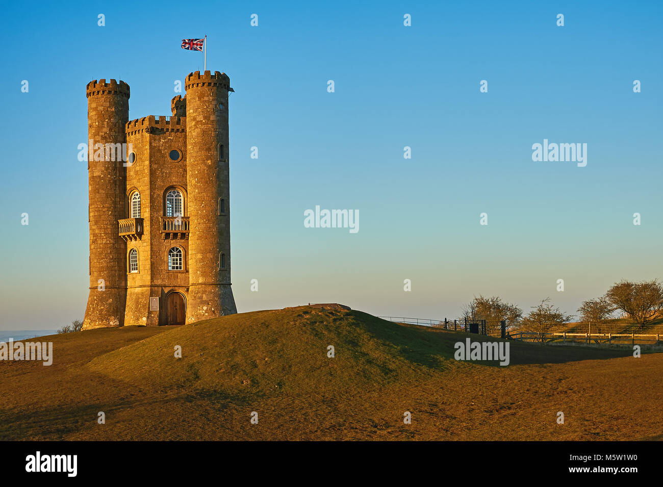 Broadway Tower, situé au sommet de la colline de poisson le deuxième plus haut point dans les Cotswolds, sur un bleu clair ciel après-midi de la fin de l'hiver. Banque D'Images