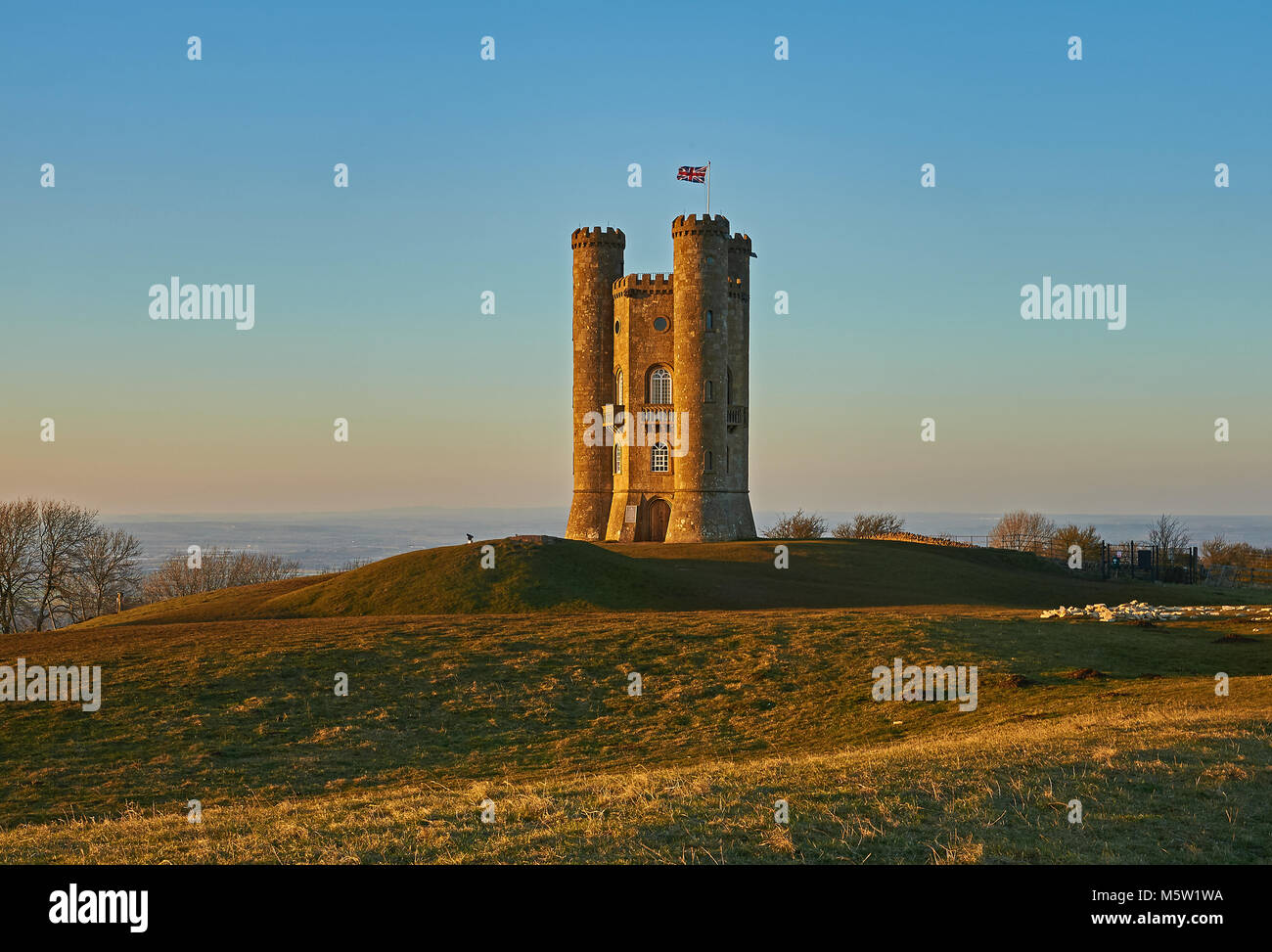 Broadway Tower, situé au sommet de la colline de poisson le deuxième plus haut point dans les Cotswolds, sur un bleu clair ciel après-midi de la fin de l'hiver. Banque D'Images
