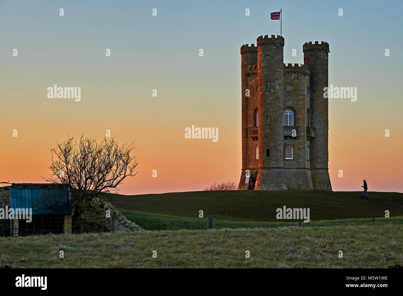 Broadway Tower sur le dessus de la colline de poisson, le deuxième plus haut point dans les Cotswolds, est un établissement emblématique, vu contre un hiver froid Ciel de coucher du soleil. Banque D'Images