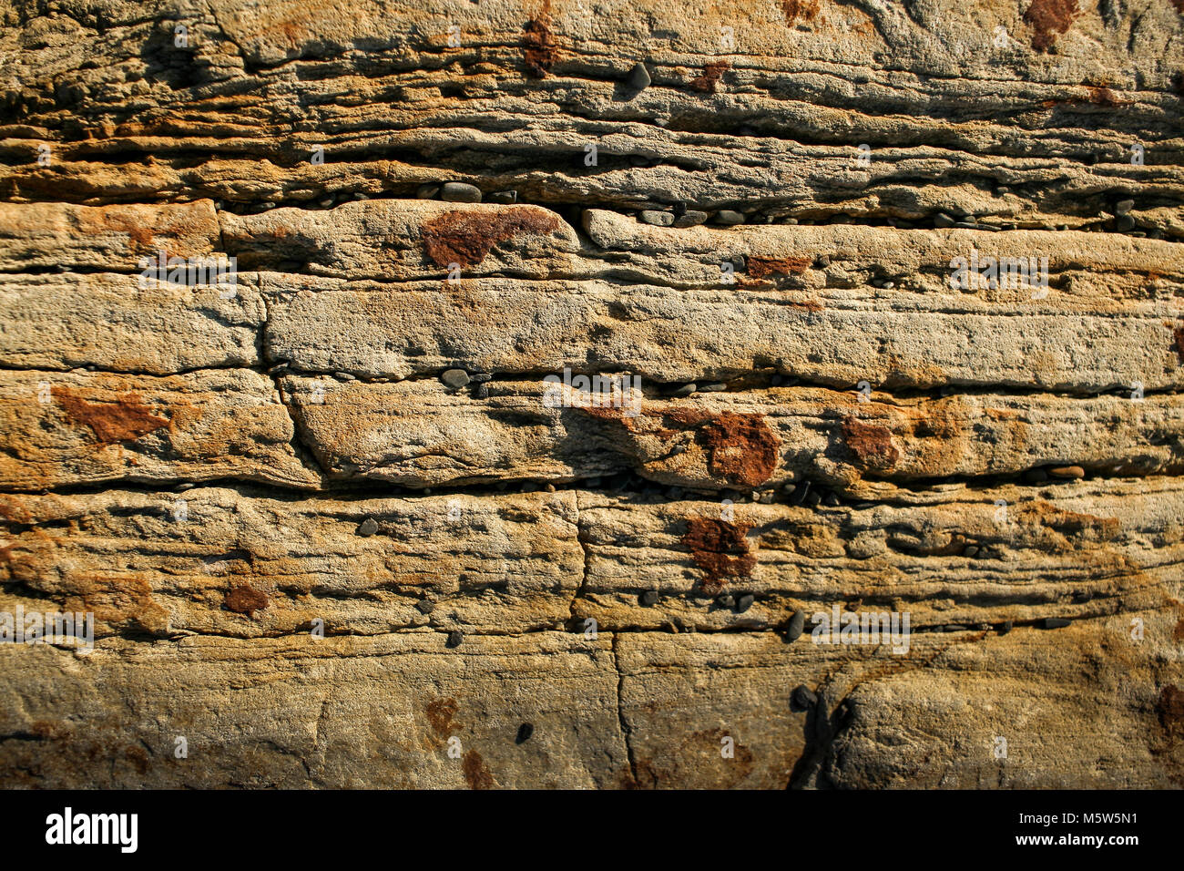 Arrière-plan de la pierre naturelle. Close-up un mur d'ardoise de montagne en couches roux. Banque D'Images