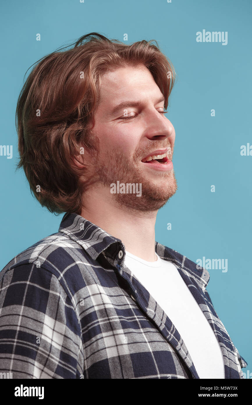 Le happy businessman standing and smiling contre fond bleu. Banque D'Images