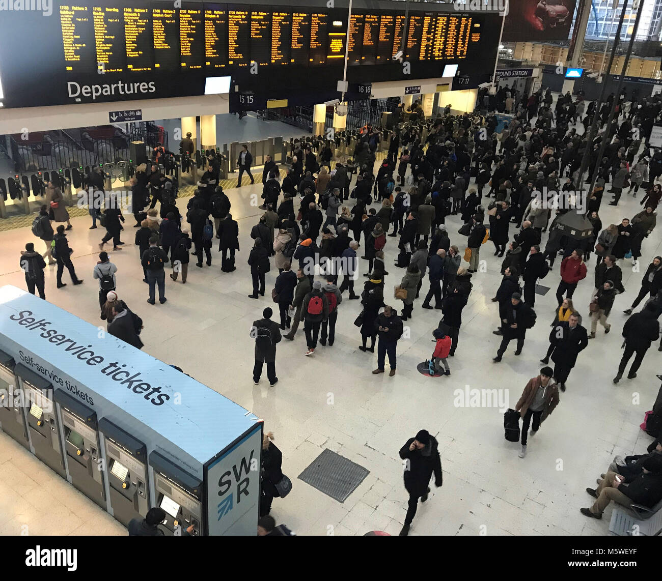 Les navetteurs à l'intérieur de la gare de Waterloo, Londres, comme ils font leur chemin de la maison au cours de la soirée, l'heure de pointe de l'avant des avertissements des compagnies de chemin de fer que les voyageurs doivent terminer leur voyage plus tôt que prévu avant d'attendre beaucoup de neige de l'automne. Banque D'Images