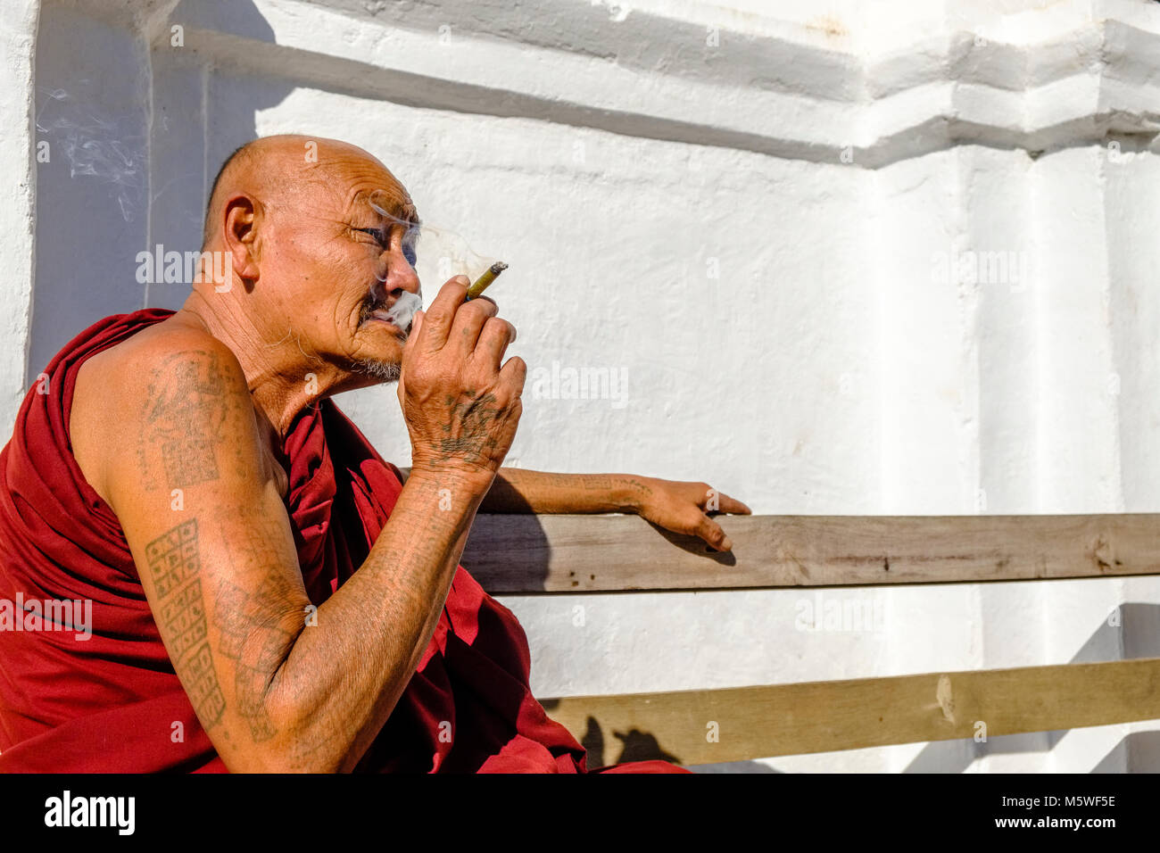 Un vieux moine, un Cheerot fumer un cigare, local à Shwe Yaunghwe Kyaung monastère Banque D'Images