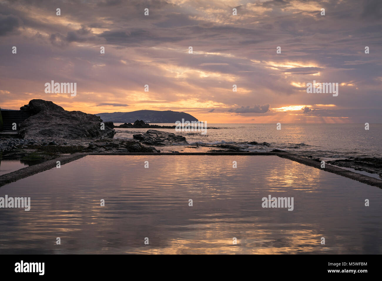 L'eau de marée à Watchet à Somerset, Angleterre un soir d'été au coucher du soleil à est vers Minehead. Banque D'Images